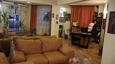 a living room with a brown leather couch at Hotel Palitra in Varna City