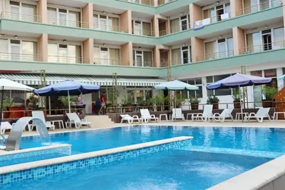a hotel swimming pool with chairs and umbrellas at Hotel Onyx in Kiten