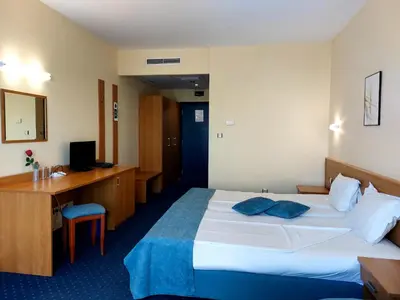 a hotel room with a bed and a desk at Aquamarine Hotel - All Inclusive in Sunny Beach