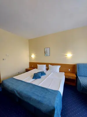 a bedroom with a large bed and a blue couch at Aquamarine Hotel - All Inclusive in Sunny Beach