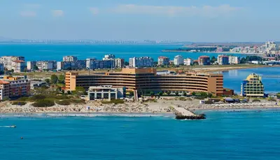 a view of a beach with a hotel and people on the beach at Grand Hotel Pomorie - Medical spa in Pomorie