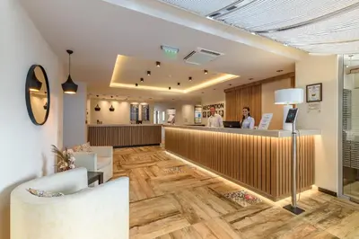 a lobby with a bar with two people standing at a counter at Lion Sunny Beach Hotel in Sunny Beach