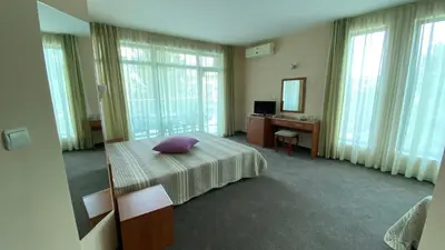 a bedroom with a bed with a purple pillow on it at Hotel L&B- Free parking in Sunny Beach