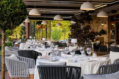 a restaurant with white tables and chairs and lights at Santa Marina Holiday Village in Sozopol