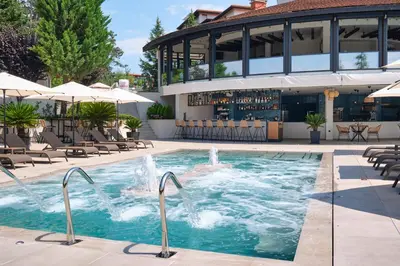 a pool at a hotel with chairs and a bar at Santa Marina Holiday Village in Sozopol