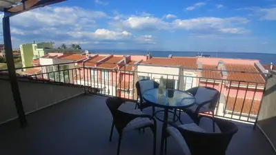 a balcony with a table and chairs and the ocean at Family Hotel Muses in Sozopol