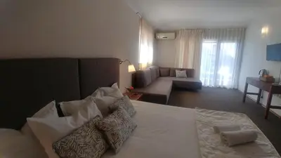a living room with a bed and a couch at Family Hotel Muses in Sozopol