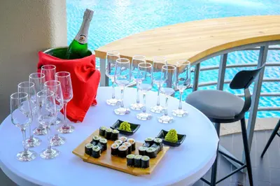 a table with glasses and sushi and a bottle of wine at Effect Grand Victoria Hotel - Ultra All Inclusive in Sunny Beach