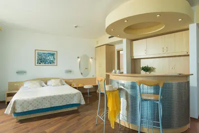 a bedroom with a bed and a kitchen with a counter at Effect Grand Victoria Hotel - Ultra All Inclusive in Sunny Beach