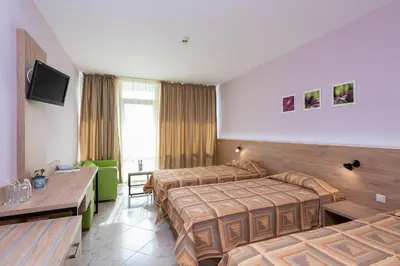 a hotel room with two beds and a couch at Ivana Palace Hotel - Free Parking in Sunny Beach