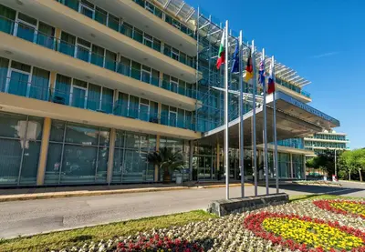 a building with flags and flowers in front of it at Ivana Palace Hotel - Free Parking in Sunny Beach