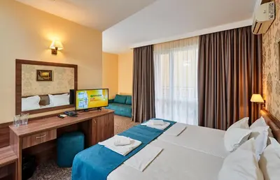 a hotel room with a bed and a desk at Sunny Beach Hotel Forum - All Inclusive in Sunny Beach