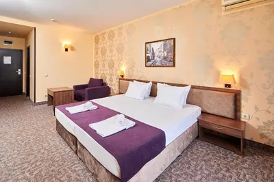 a hotel room with a bed and a chair at Sunny Beach Hotel Forum - All Inclusive in Sunny Beach