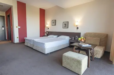 a bedroom with a bed and a table and a couch at Flamingo Hotel Sunny Beach in Sunny Beach