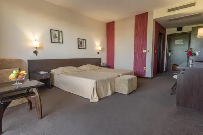 a hotel room with a bed and a couch at Flamingo Hotel Sunny Beach in Sunny Beach