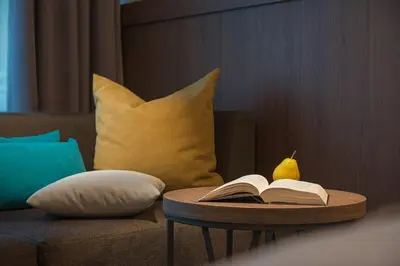 a table with an open book on top of a couch at Hotel Alba - All inclusive in Sunny Beach