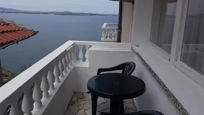 a black chair sitting on a balcony overlooking the water at ORION Guest House in Sozopol
