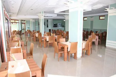 a dining room with wooden tables and chairs at Serena Residence Aparthotel in Sozopol