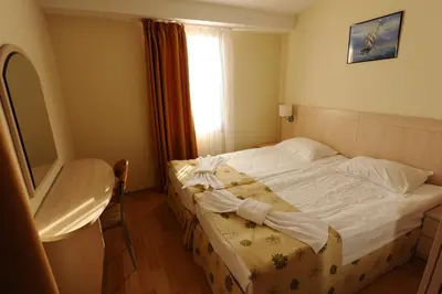 a bedroom with a white bed with a window at Serena Residence Aparthotel in Sozopol