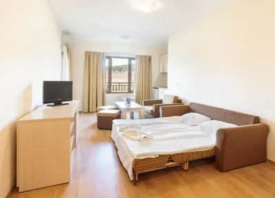 a bedroom with a bed and a living room at Serena Residence Aparthotel in Sozopol