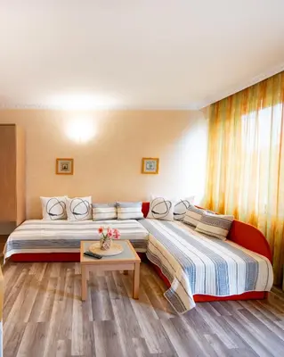 a hotel room with two beds and a table at Hotel Zeus in Pomorie