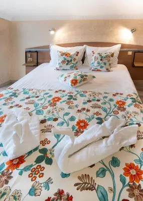 a bedroom with a bed with towels on it at Hotel Zeus in Pomorie