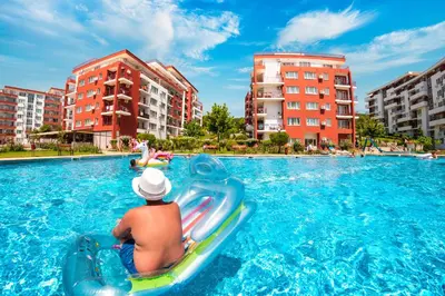 a man riding on a raft in a swimming pool at Grand Resort in Sveti Vlas