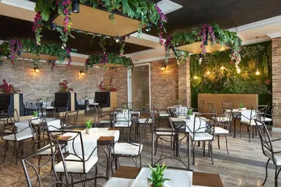 a restaurant with tables and chairs and flowers at Paradise Beach Residence - Ultra All Inclusive in Sveti Vlas