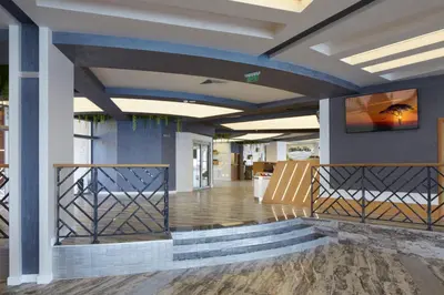 a lobby with a staircase and a television on a wall at Paradise Beach Residence - Ultra All Inclusive in Sveti Vlas