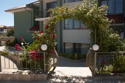 an arch with flowers in front of a building at Gardenia Vacation Settlement in Sozopol