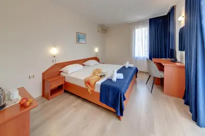 a hotel room with a bed and a desk at Семеен хотел Амон Ра in Sozopol