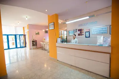 a woman is standing behind a counter in a pharmacy at Hotel Bohemi in Sunny Beach