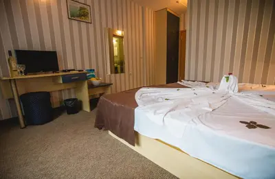 a hotel room with a large bed with white sheets at Hotel Bohemi in Sunny Beach