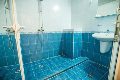 a blue tiled bathroom with a sink and a shower at Hotel Bohemi in Sunny Beach