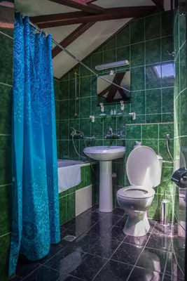 a green tiled bathroom with a toilet and a sink at Victoria Hotel Nessebar in Nesebar