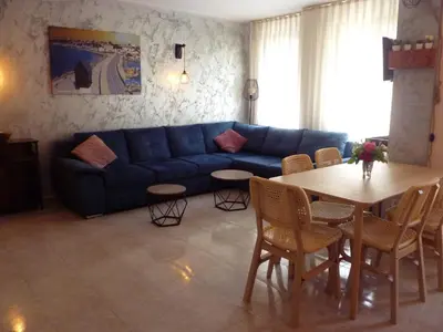 a living room with a blue couch and a table at Apartment Tourist Complex Rose Village in Sunny Beach