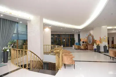 a lobby with stairs and chairs in a building at Hotel Primorsko Del Sol in Primorsko