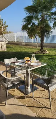 a table with a plate of food and two chairs at Alex Beach Apartment in Sveti Vlas