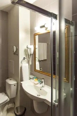 a bathroom with a sink and a toilet and a mirror at Regata Palace Hotel in Sunny Beach