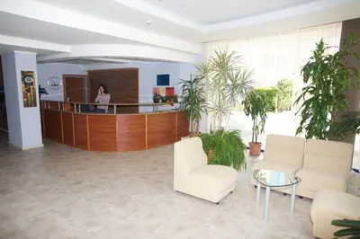 a lobby with white chairs and a woman in the background at Dunav Hotel in Sunny Beach