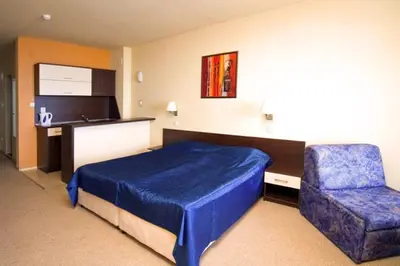a bedroom with a blue bed and a chair at Carina Beach in Sunny Beach