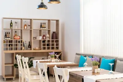 a dining room with a table and chairs and a couch at iHotel Sunny Beach in Sunny Beach