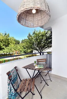 a wooden table and chairs on a patio with a chandelier at iHotel Sunny Beach in Sunny Beach