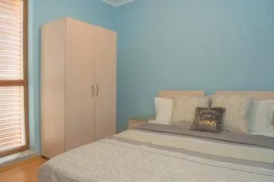 a bedroom with a large bed and a cabinet at Sun City I Apartments in Sunny Beach