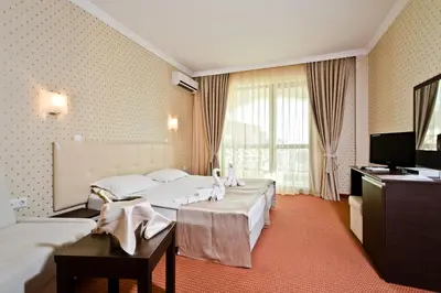 a hotel room with two beds and a television at Saint George Palace Hotel All-inclusive in Sveti Vlas