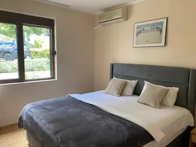 a bedroom with a large bed with a window at Dolce Vita Apartment in Sveti Vlas