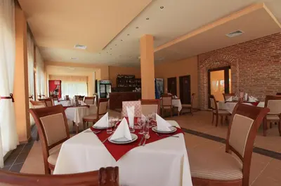 a dining room with white tables and chairs at Galeria Holiday Apartments in Obzor