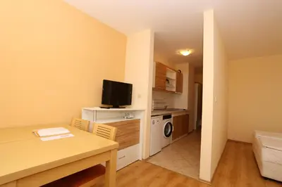 a small apartment with a dining table and a kitchen at Galeria Holiday Apartments in Obzor