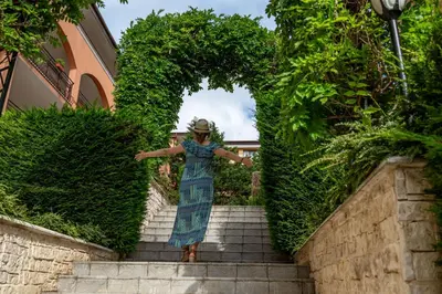 a woman in a dress is walking up some stairs at Galeria Holiday Apartments in Obzor
