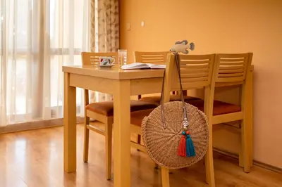 a dining room table and chairs with a table and a basket at Galeria Holiday Apartments in Obzor